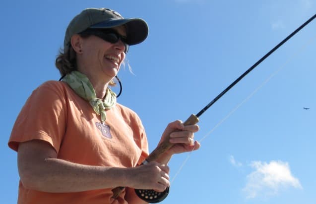 Two anglers casting from the bow on a glassy Andros flat