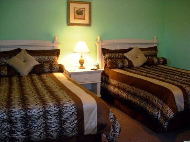 An air-conditioned guest room at Two Boys' Inn with two queen beds and private bath