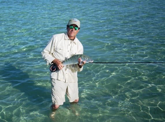 Tailing bonefish breaking the glassy surface of a dawn flat
